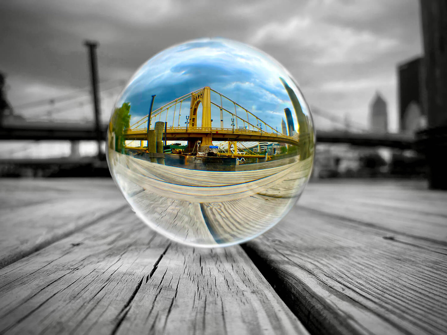 Photograph of a glass sphere reflecting the Roberto Clemente Bridge.