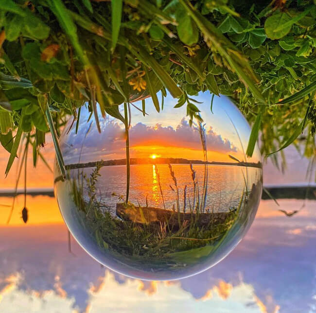 Crystal ball reflecting the sunset and shore of Edinboro Lake.
