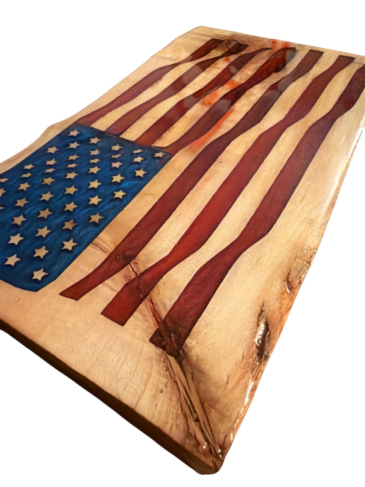 Detailed close-up of blue mica stars and red mica stripes on polished wood grain coated in epoxy resin.