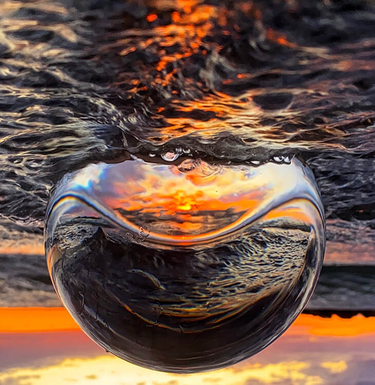Crystal ball reflecting the sunset and water of Presque Isle.