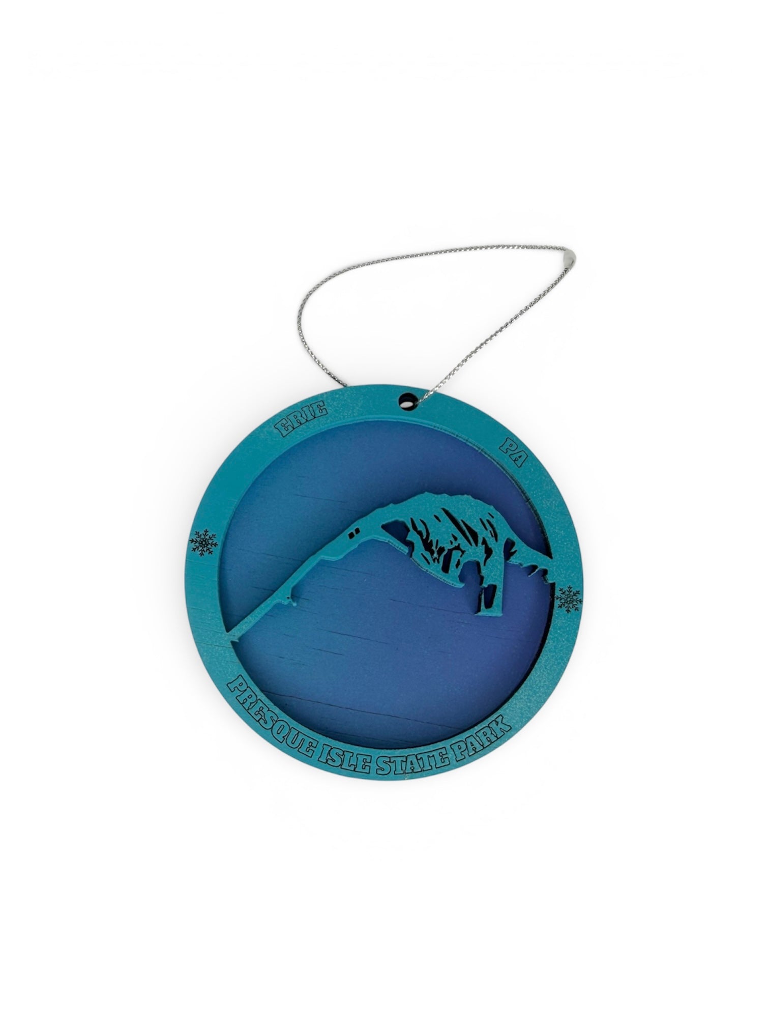 Layered wood Christmas ornament featuring a teal cutout of the Presque Isle State Park shoreline, engraved with "Presque Isle State Park," "Erie, PA," and delicate snowflake details.